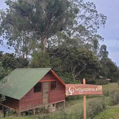 a smallshed with a sign in front of a tree at Sukha Glamping in Rionegro