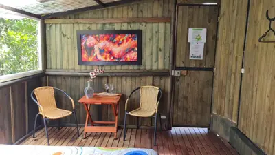 a porch with a table and two chairs and a tv at Sukha Glamping in Rionegro