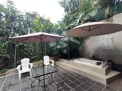 two chairs and a table with two umbrellas and a bath tub at Aparta Hotel LOFT Campestre Jacuzzi Poblado apt 107 in Medellín