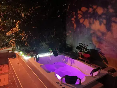a hot tub with purple lighting in a yard at night at Aparta Hotel LOFT Campestre Jacuzzi Poblado apt 107 in Medellín