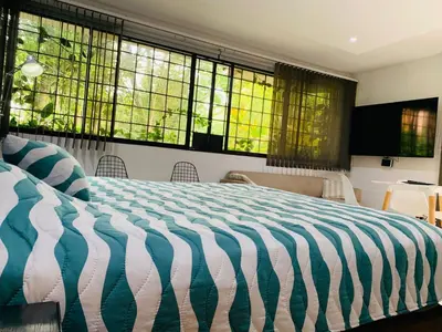 a bedroom with a large bed and windows at Aparta Hotel LOFT Campestre Jacuzzi Poblado apt 107 in Medellín