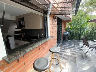 a balcony with a kitchen and two stools on a patio at Aparta Hotel LOFT Campestre Jacuzzi Poblado apt 107 in Medellín