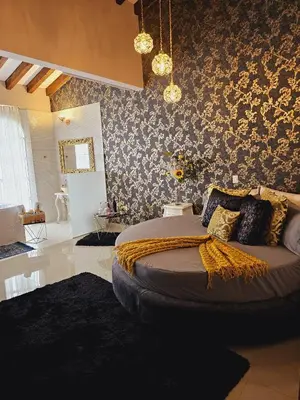 a bedroom with a large bed with floral wallpaper at Hotel Mansion Sant Serrant Medellín- Aeropuerto Rionegro in Marinilla