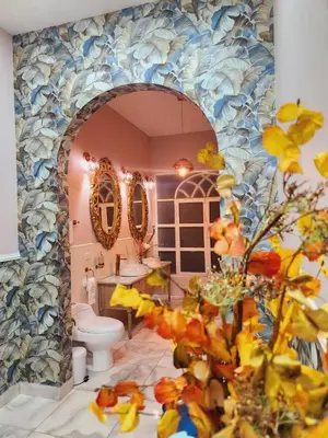 a bathroom with a toilet and a mosaic wall at Hotel Mansion Sant Serrant Medellín- Aeropuerto Rionegro in Marinilla