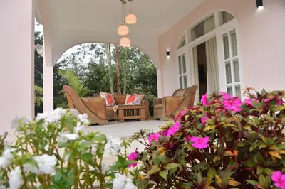 a porch with couches and flowers on a house at Hotel Mansion Sant Serrant Medellín- Aeropuerto Rionegro in Marinilla