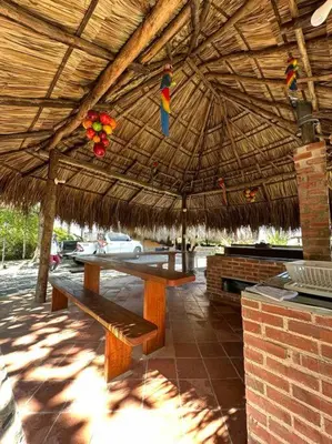 a pavilion with a picnic table and a straw umbrella at increible casa de campo con piscina y jacuzzi! in Támesis
