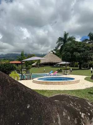 a swimming pool with chairs and umbrellas in a park at increible casa de campo con piscina y jacuzzi! in Támesis