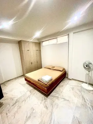 a bedroom with a bed with marble floors and a fan at La Posada de Miguel in Medellín