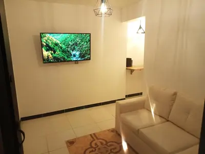 a living room with a couch and a television on a wall at Apartamento acogedor en Medellín in Medellín