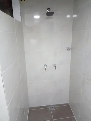 a bathroom with a shower with white tiles at Apartamento acogedor en Medellín in Medellín