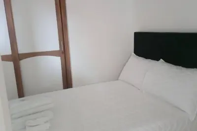 a white bed with a black headboard and white sheets at Apartamento acogedor en Medellín in Medellín