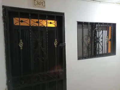 a black door and a window on a white wall at Apartamento acogedor en Medellín in Medellín