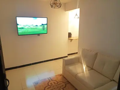 a living room with a couch and a tv on a wall at Apartamento acogedor en Medellín in Medellín
