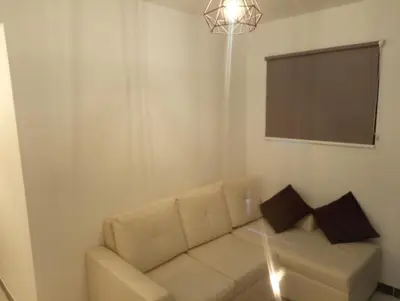 a living room with a white couch with two pillows at Apartamento acogedor en Medellín in Medellín