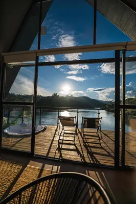 a deck with chairs and a view of the water at 5CHALETS in Guatapé