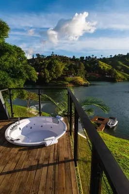 a bath tub sitting on a deck next to a river at 5CHALETS in Guatapé