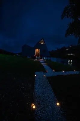 a small house at night with lights on the ground at 5CHALETS in Guatapé
