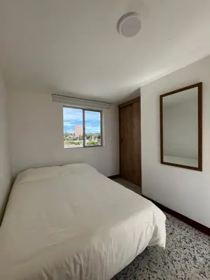 a white bedroom with a bed and a window at Casa Blanca Hostal in Rionegro