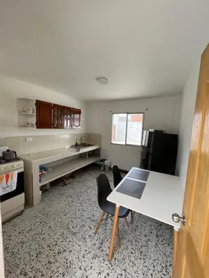 a kitchen with a desk and a table with chairs at Casa Blanca Hostal in Rionegro