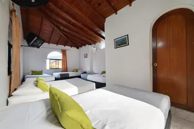 a room with four beds and a couch at Ayenda 1234 Imperio 70 in Medellín