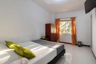 a bedroom with a bed with a yellow pillow on it at Ayenda 1234 Imperio 70 in Medellín