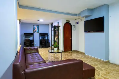 a living room with a brown leather couch and a table at Ayenda 1234 Imperio 70 in Medellín
