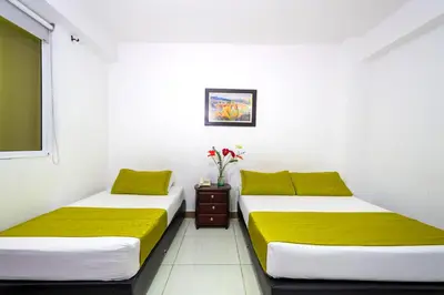 two beds in a room with white walls at Ayenda 1234 Imperio 70 in Medellín