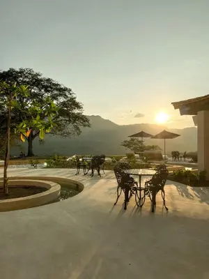 a table and chairs with the sunset in the background at Hotel Tahiti in Puente Iglesias