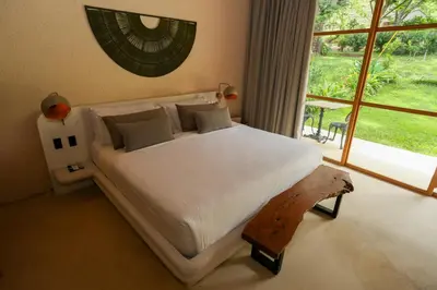 a bedroom with a white bed with a large window at Hotel Tahiti in Puente Iglesias