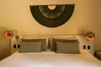 a bedroom with a white bed with two pillows at Hotel Tahiti in Puente Iglesias