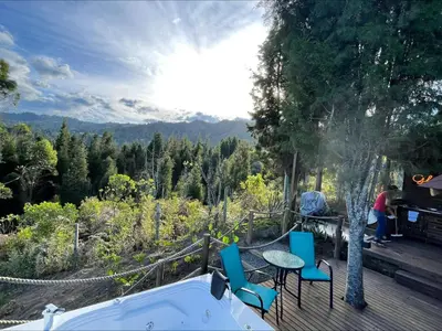 a deck with chairs and a table and a bath tub at Entre-pinos Glamping WiFi Vista 360º in Guarne