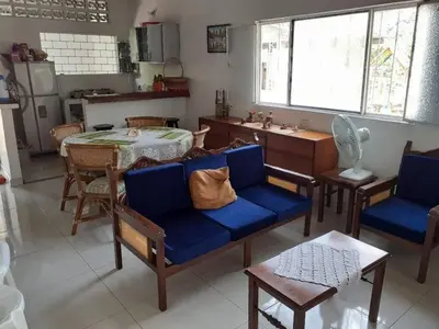 a living room with blue chairs and a table and a kitchen at Hospedaje casa completa Honda Tolima in Honda