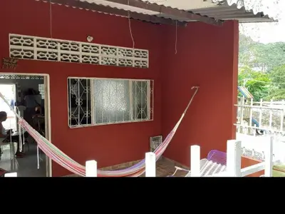 a red building with a hammock in front of a window at Hospedaje casa completa Honda Tolima in Honda