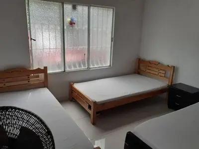 a bedroom with two beds and two windows at Hospedaje casa completa Honda Tolima in Honda