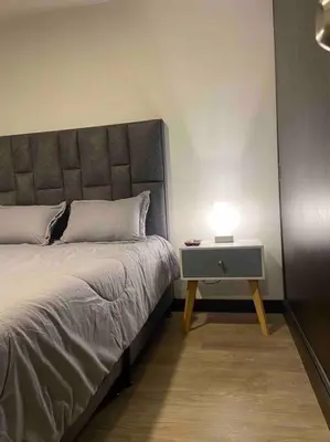 a bed with a side table with a lamp on it at Apartamento nuevo centro histórico! in Manizales