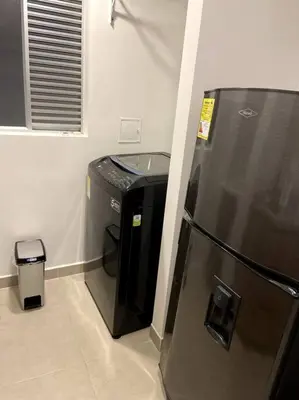 a kitchen with a refrigerator and a trash can at Apartamento nuevo centro histórico! in Manizales
