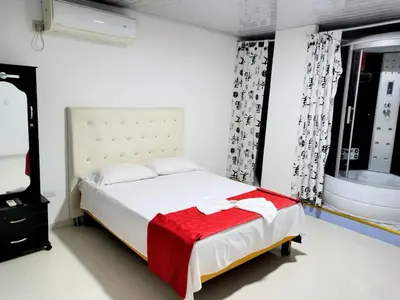 a bedroom with a bed with a red blanket on it at Hotel flamingo real T in Mariquita