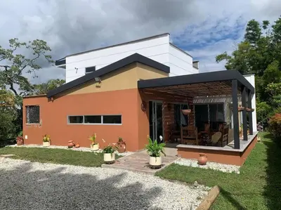 a small house with a black roof at Hermosa casa de campo en ambiente tranquilo. in Rionegro