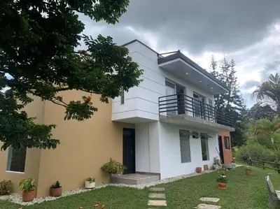 a white and yellow house with a yard at Hermosa casa de campo en ambiente tranquilo. in Rionegro