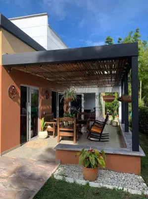 a patio with a table and chairs under a pergola at Hermosa casa de campo en ambiente tranquilo. in Rionegro