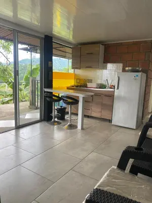 a kitchen with a refrigerator and a table and chairs at Tierra Mágica eje cafetero in Manizales