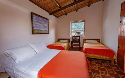 a bedroom with two beds and a chair in it at Hotel Kantarrana Urbana Jardin in Jardin