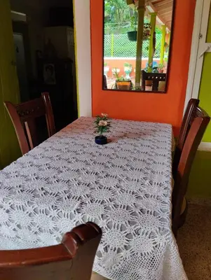 a table with a white table cloth with a flower on it at Casa Mamá Chelita in Titiribí