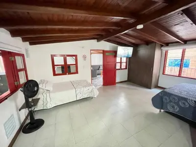 a bedroom with a bed and a room with two windows at Vacaciones con tu mascota Loft con terraza Mayorca in Sabaneta