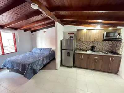 a kitchen with a bed and a refrigerator in a room at Vacaciones con tu mascota Loft con terraza Mayorca in Sabaneta