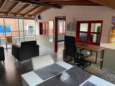 a living room with a table and chairs and a desk at Vacaciones con tu mascota Loft con terraza Mayorca in Sabaneta