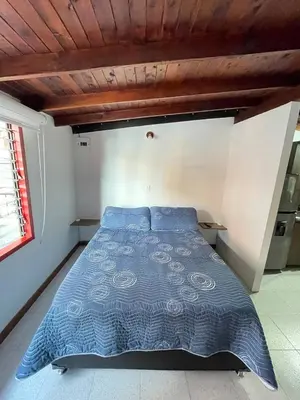 a bed with a blue comforter in a bedroom at Vacaciones con tu mascota Loft con terraza Mayorca in Sabaneta