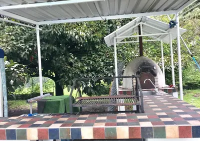 a picnic table with a bench and an outdoor oven at CASAQUINTA PRIVADA MARIQUITA-TOLIMA in Mariquita