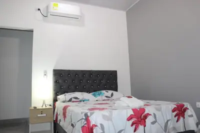 a bedroom with a bed with a black headboard at Como en casa 2 in La Dorada
