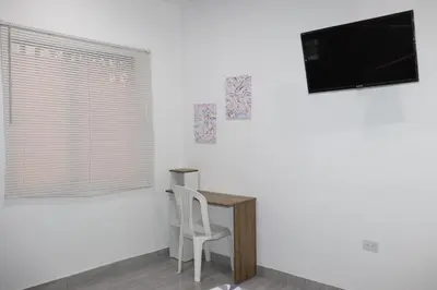 a white room with a desk and a tv on the wall at Como en casa 2 in La Dorada